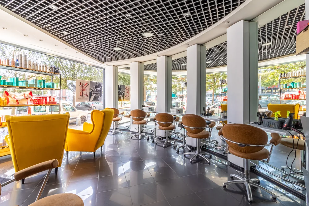 Intérieur panoramique de Mon Salon, coiffeur à Dunkerque, fauteuils jaunes et plafond en trame noire